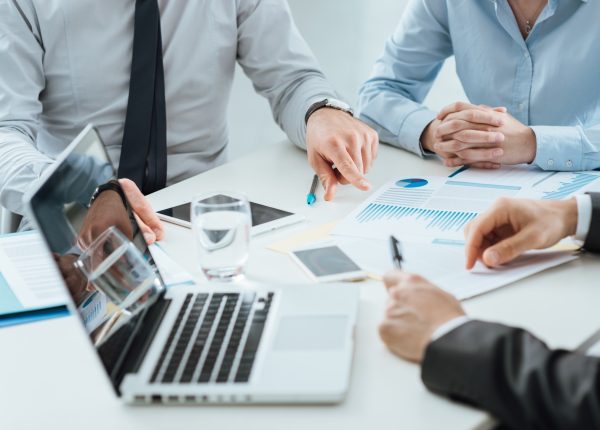 Professional business team working together at office desk discussing during a meeting, efficiency and teamwork concept